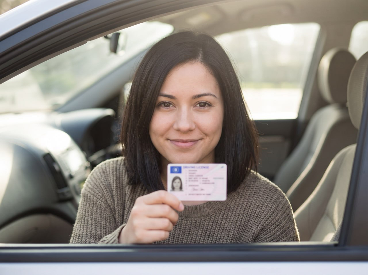 Client showing her German driving licence in a car park